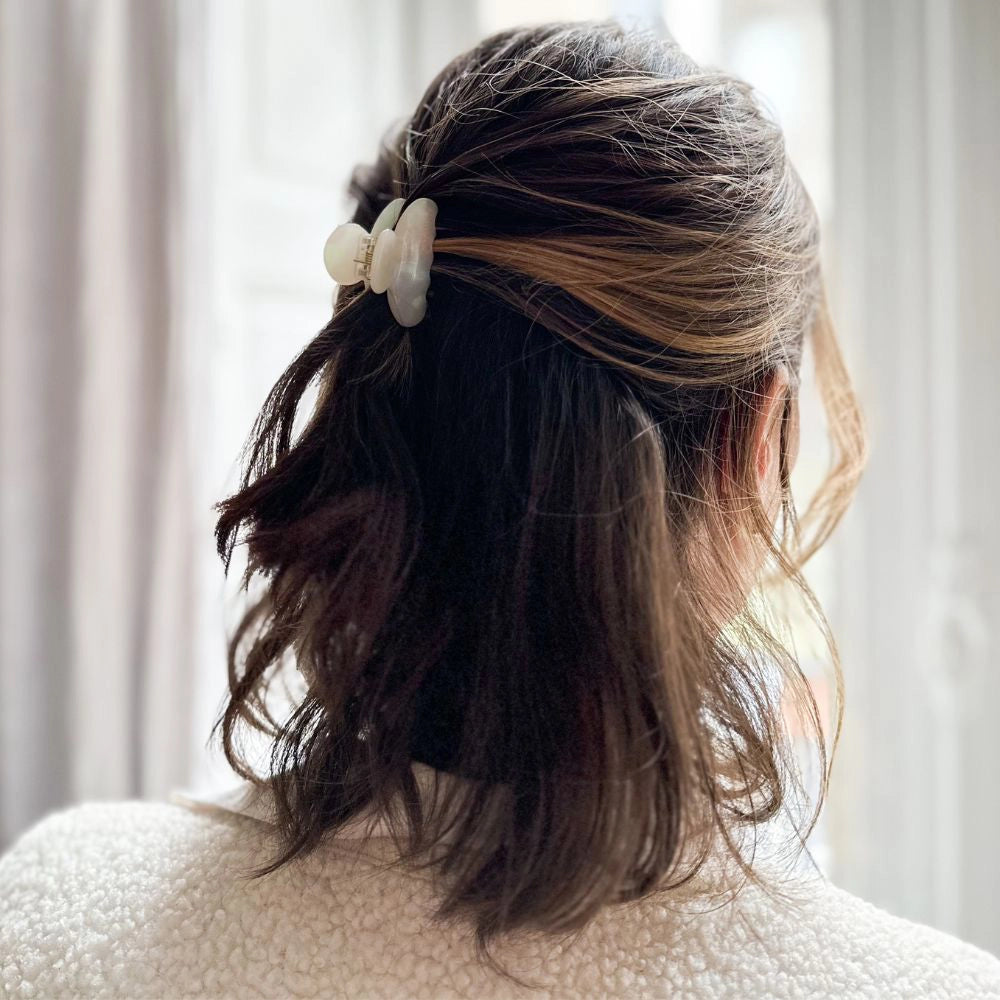 Person with hair styled in a half-up, half-down look with pearl claw clip in classic size against a neutral background