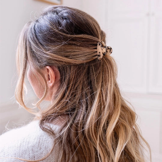 Woman with long, wavy hair tied back with the Bachca classic tortoiseshell claw clip against a neutral background