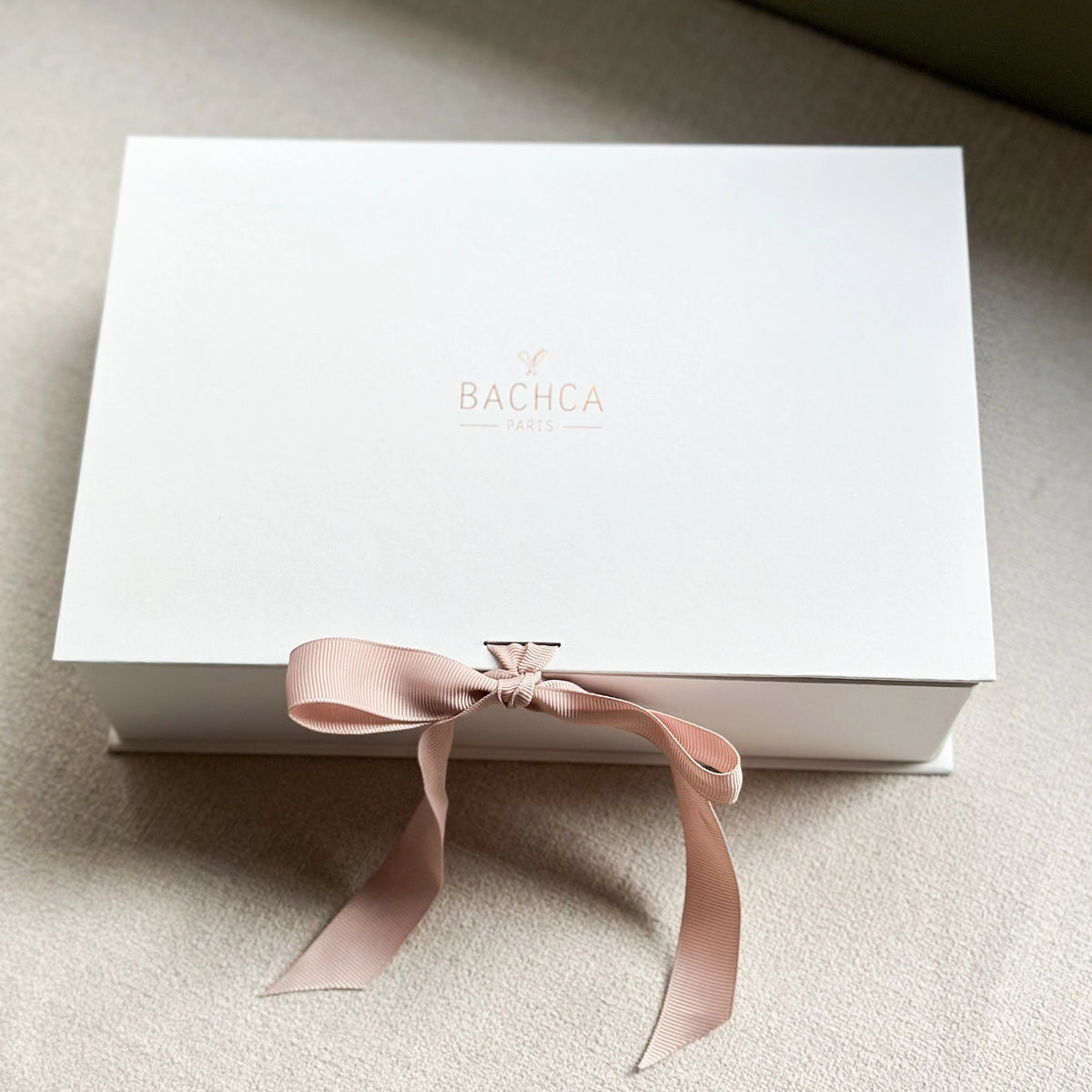 White box with a pink ribbon and &