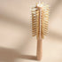 Bachca round styling brush in natural wood, positioned vertically, showing the rows of mixed boar and nylon bristles, on a soft beige background with subtle shadows.