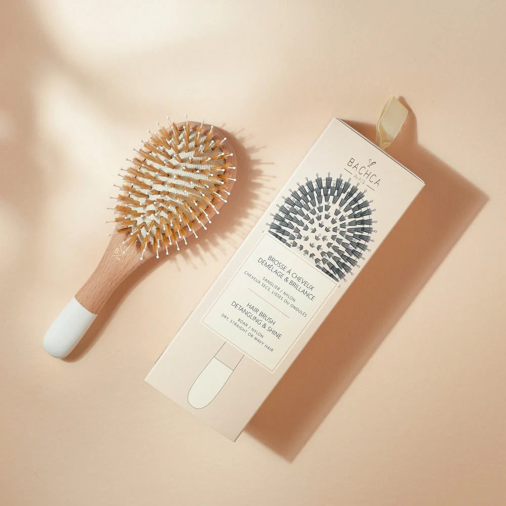 Bachca Gloss and Detangling Hair Brush in small size laying next to the box packaging. 