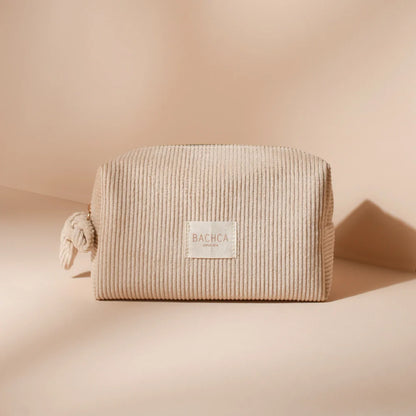 BACHCA velvet makeup pouch in beige corduroy, placed on a cream background in natural light.